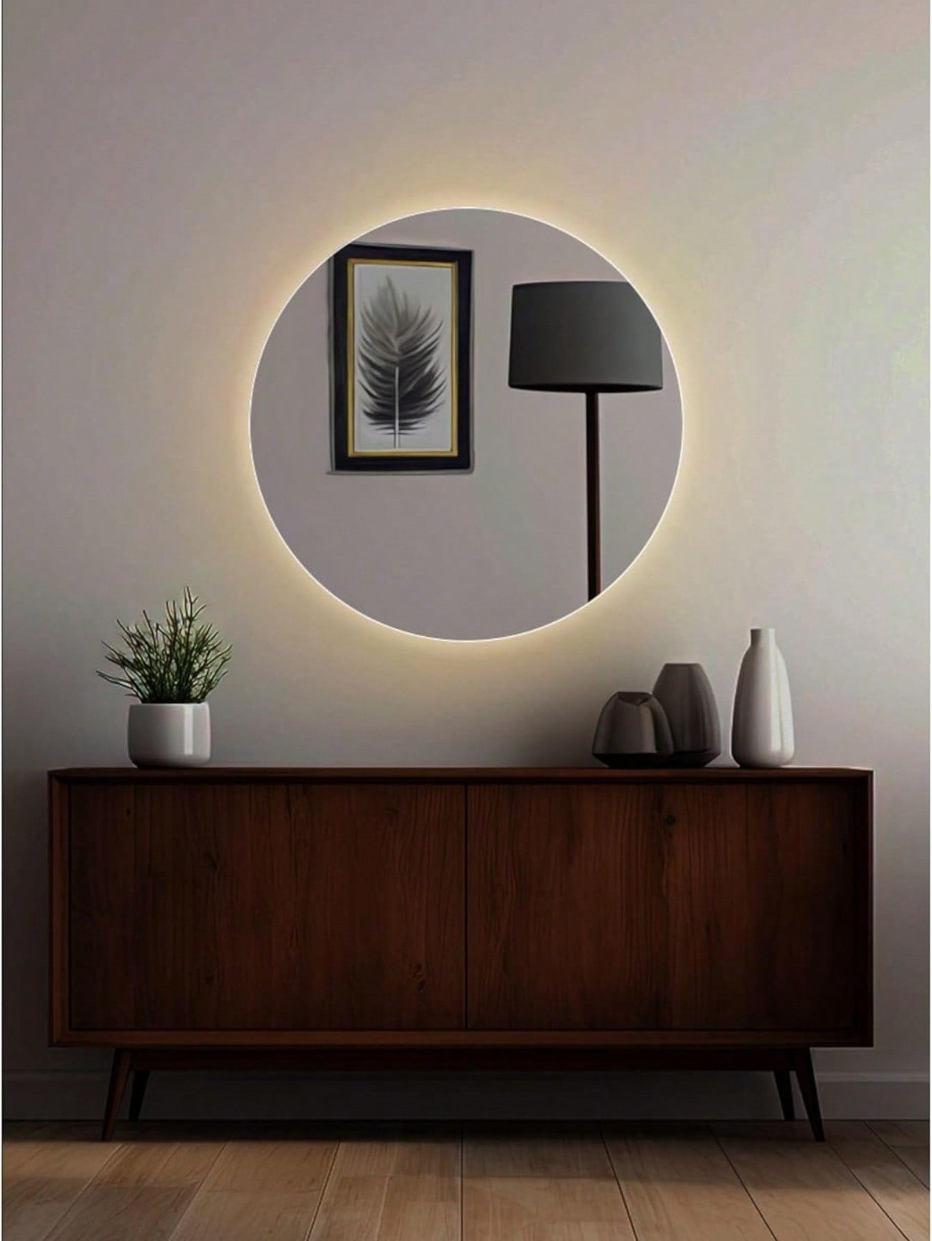 Espejo circular moderno con luz LED ambiental sobre mueble de madera oscuro en sala minimalista