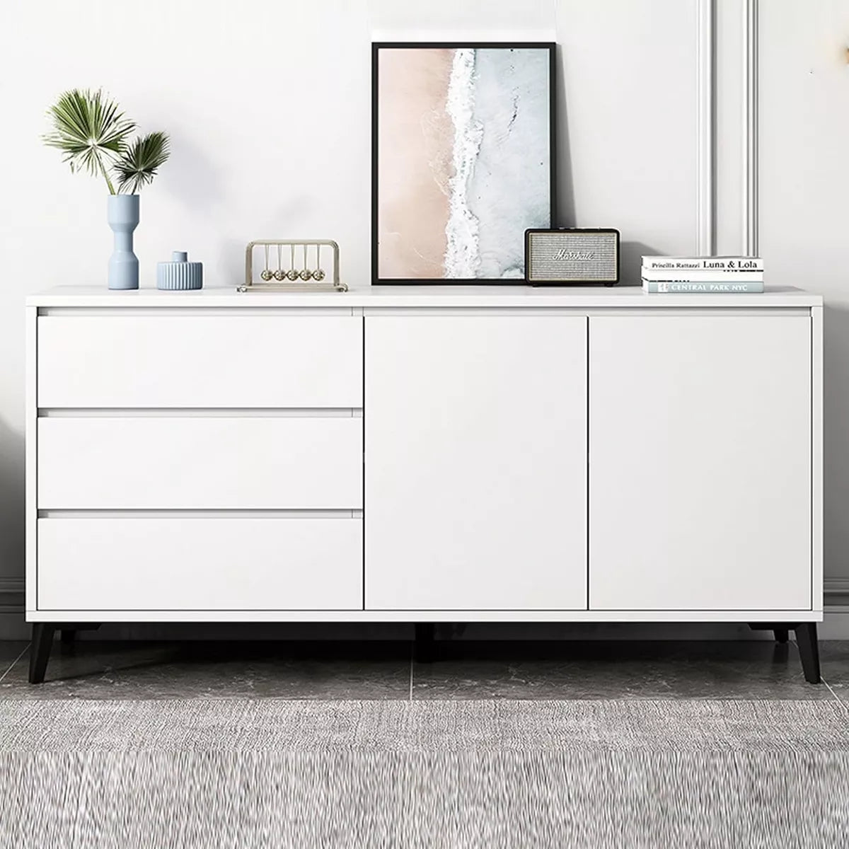 Cómoda de lujo moderna blanca con tres cajones y dos puertas sobre patas negras en sala minimalista